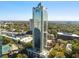 A modern skyscraper with reflective glass, nestled in a vibrant green landscape and neighborhood views at 2828 Peachtree Nw Rd # 1502, Atlanta, GA 30305