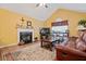 Comfortable living room with a fireplace, wood floors, vaulted ceiling, and a cozy leather sofa at 4040 Brightmore Dr, Austell, GA 30106