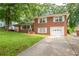 Red brick home with attached one car garage and a long driveway at 1558 Boulderwoods Se Dr, Atlanta, GA 30316
