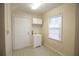 Laundry room featuring utility sink, storage cabinet, and tiled floor at 1558 Boulderwoods Se Dr, Atlanta, GA 30316