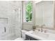 Bathroom with marble walk-in shower, natural light, and navy blue vanity at 298 Saint Marys Nw Ln, Marietta, GA 30064