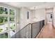 Light-filled hallway showcasing hardwood floors, a modern chandelier, and a staircase with large windows at 298 Saint Marys Nw Ln, Marietta, GA 30064