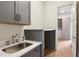 Laundry room featuring a sink, gray cabinets, and marble countertops with a view of the closet at 298 Saint Marys Nw Ln, Marietta, GA 30064