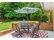 Enjoy outdoor dining on this charming patio with patterned rug, surrounded by mature trees and greenery at 579 Chapman Dr, Marietta, GA 30066