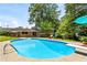 Relax and unwind by the swimming pool with a diving board, lush greenery and patio seating at 579 Chapman Dr, Marietta, GA 30066