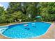 Enjoy a refreshing dip in this swimming pool surrounded by lush greenery, seating and mature trees at 579 Chapman Dr, Marietta, GA 30066