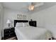This bedroom features a ceiling fan, light colored walls, and a comfortable bed with dark colored furniture at 335 Pintail Ct, Suwanee, GA 30024