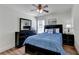 This is a cozy bedroom with a ceiling fan, a black dresser with a mirror, and a comfy bed with a nightstand at 335 Pintail Ct, Suwanee, GA 30024