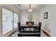 Bright dining room featuring hardwood floors, a wooden dining set, and a large window offering ample natural light at 335 Pintail Ct, Suwanee, GA 30024