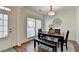 Elegant dining room with hardwood floors, a wooden table with chairs and bench, and natural light from the windows at 335 Pintail Ct, Suwanee, GA 30024