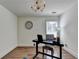 Home office featuring a modern desk, chair, a chandelier, wood floor, and a large window at 335 Pintail Ct, Suwanee, GA 30024