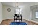 Well lit room with wood floor, desk, chair, chandelier and view to other rooms with staircase at 335 Pintail Ct, Suwanee, GA 30024