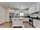 Clean kitchen with stainless appliances, white cabinets, an island, and hardwood floors at 335 Pintail Ct, Suwanee, GA 30024