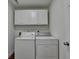 Well-organized laundry room with washer, dryer, and white cabinets at 335 Pintail Ct, Suwanee, GA 30024
