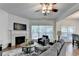 Comfortable living room with a fireplace, hardwood floors, a ceiling fan, and ample natural light from the large window at 335 Pintail Ct, Suwanee, GA 30024