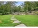 Beautiful backyard with stone walkway leading to seating area and wooded area at 287 Flower Farm Dr, Acworth, GA 30101