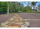 View of backyard featuring rock drainage, mature trees, and lush landscaping at 287 Flower Farm Dr, Acworth, GA 30101