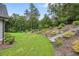 Beautifully landscaped backyard featuring lush green lawn, stone steps, and mature trees at 287 Flower Farm Dr, Acworth, GA 30101