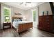 Comfortable bedroom with wood-look flooring, ceiling fan and two windows showcasing lush greenery at 287 Flower Farm Dr, Acworth, GA 30101