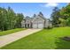 Exterior view of home with a two-car garage, well-maintained lawn, and a covered front porch at 287 Flower Farm Dr, Acworth, GA 30101