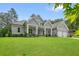 Gray home exterior featuring a large front lawn, two-car garage, and a covered porch with stone accents at 287 Flower Farm Dr, Acworth, GA 30101