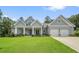 Exterior shot of gray single story house with two-car garage, welcoming covered porch, and pristine landscaping at 287 Flower Farm Dr, Acworth, GA 30101