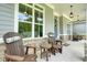 Inviting covered porch with rocking chairs, stone accents, stylish lighting, and gray wood siding at 287 Flower Farm Dr, Acworth, GA 30101
