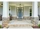 Welcoming front porch with rocking chairs, stone columns, hanging lanterns, and a striking blue door at 287 Flower Farm Dr, Acworth, GA 30101