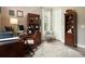 Home office featuring dark wood desk, shelving, light-colored chair, and wood floors at 287 Flower Farm Dr, Acworth, GA 30101