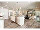 Open concept kitchen featuring an island with seating, granite counters and stainless appliances open to the living room at 287 Flower Farm Dr, Acworth, GA 30101
