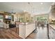 Open concept kitchen with island seating featuring granite counters and stainless appliances flowing into the living and dining rooms at 287 Flower Farm Dr, Acworth, GA 30101