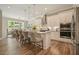 Bright kitchen with an island, breakfast bar, granite counters, stainless appliances, and wood grain tile flooring at 287 Flower Farm Dr, Acworth, GA 30101