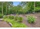 Landscaped garden with flowering bushes, stone pathway, and mature trees at 287 Flower Farm Dr, Acworth, GA 30101