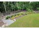 Professionally landscaped yard with mature trees, ornamental plantings, and a black fence at 287 Flower Farm Dr, Acworth, GA 30101