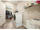 Functional laundry room with washer, dryer, utility sink, and access to walk-in closet at 287 Flower Farm Dr, Acworth, GA 30101