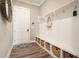 Charming mud room featuring cubbies, hooks, and decorative mirror near a white paneled door at 287 Flower Farm Dr, Acworth, GA 30101