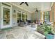 Covered patio with wicker furniture, ceiling fans, string lights, and stone flooring at 287 Flower Farm Dr, Acworth, GA 30101