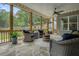 Screened-in porch with wicker seating, stone flooring, and backyard view at 287 Flower Farm Dr, Acworth, GA 30101