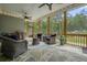Screened-in patio with wicker furniture, ceiling fans, and a view of the wooded backyard at 287 Flower Farm Dr, Acworth, GA 30101