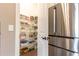 Walk-in pantry with ample shelving and storage space, perfect for organizing all your kitchen essentials with stainless steel refrigerator at 3900 Danube Ln, Atlanta, GA 30339