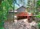 View of the home showcasing its backyard deck and wooded surroundings at 4915 Millers Trce, Peachtree Corners, GA 30096