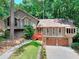 Front exterior view of a home featuring a two car garage and lush trees at 4915 Millers Trce, Peachtree Corners, GA 30096