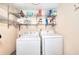 Functional laundry area with shelving and white washer and dryer at 4915 Millers Trce, Peachtree Corners, GA 30096
