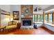 Living room featuring a stone fireplace and window seating in a naturally lit space at 4915 Millers Trce, Peachtree Corners, GA 30096