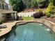 A serene backyard featuring a gorgeous pool with stone accents, lush lawn, and ample lounge seating at 970 Tarpley Nw Rd, Kennesaw, GA 30152