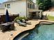 Lounge by the pool and enjoy this landscaped backyard with dining and lounging areas on a stone-paved patio at 970 Tarpley Nw Rd, Kennesaw, GA 30152