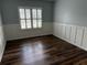 Cozy bedroom with wainscoting, hardwood floors, and a view of the well manicured front yard at 970 Tarpley Nw Rd, Kennesaw, GA 30152