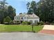 Well-manicured lawn highlights this two-story house, showcasing a brick driveway and a meticulously landscaped yard at 970 Tarpley Nw Rd, Kennesaw, GA 30152