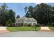 Inviting two-story home with a lush lawn, manicured landscaping, and a brick driveway, surrounded by mature trees at 970 Tarpley Nw Rd, Kennesaw, GA 30152