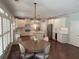 Open eat-in kitchen with white cabinets, stainless steel appliances, center island, hardwood floors, and modern lighting at 970 Tarpley Nw Rd, Kennesaw, GA 30152
